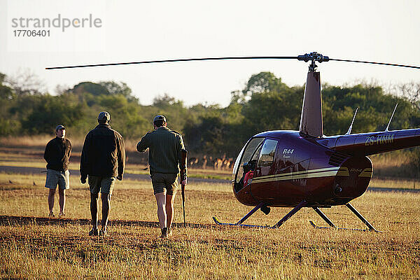 Tierarzt und Pilot an Bord eines Hubschraubers nach dem Einkerben eines Nashorns  Phinda Private Game Reserve; Südafrika