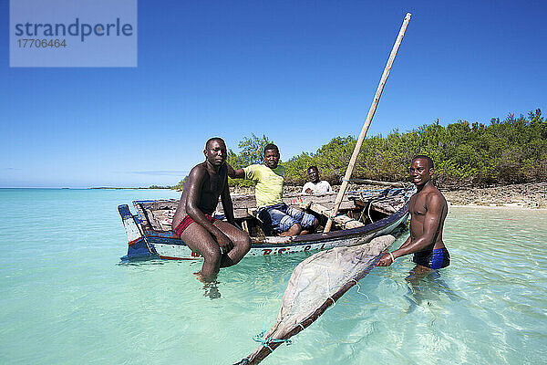 Männer sitzen in einem alten hölzernen Segelboot in der Nähe des Ufers; Vamizi Island  Mosambik