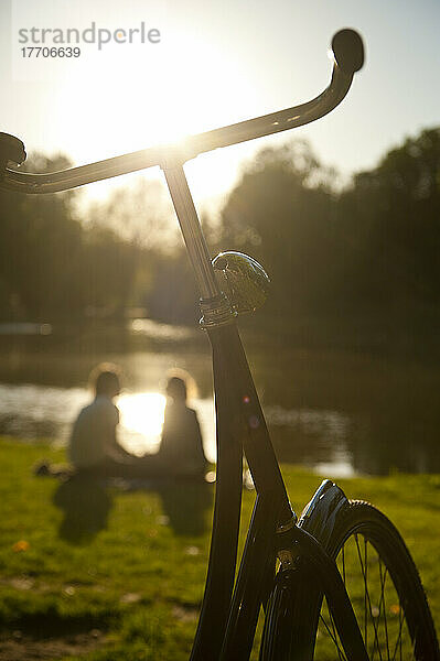 Paar entspannt sich neben dem See im Vondelpark am Abend; Amsterdam  Holland