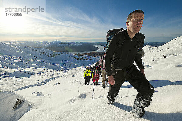 Wanderer gehen durch schweren Schnee auf den Beinn Respiol  Ardnamurchan-Halbinsel  Highlands  Schottland