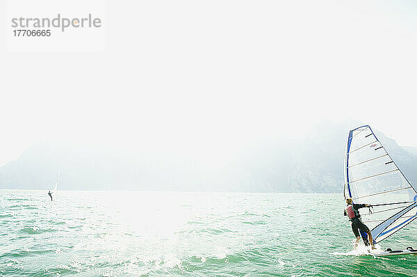 Eine Frau beim Windsurfen auf dem Gardasee; Riva Del Garda  Trento  Norditalien