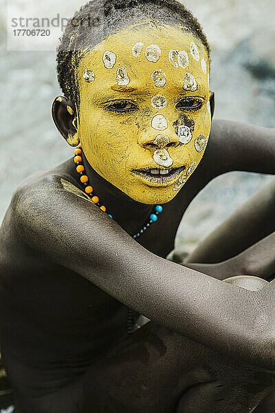 Junger Junge mit traditionell bemaltem Gesicht  Farbe aus natürlich geschliffenen Flusssteinen  Region Omo  Südwest-Äthiopien; Kibish  Äthiopien