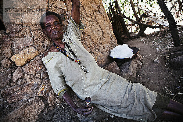 Porträt einer Frau  die Baumwolle mit einer traditionellen Spule spinnt; Äthiopien