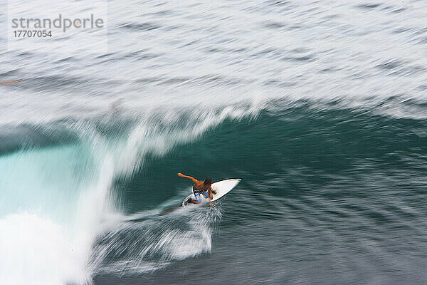 Ein Surfer bereitet sich darauf vor  über scharfe Korallen in Indonesien geschleudert zu werden.