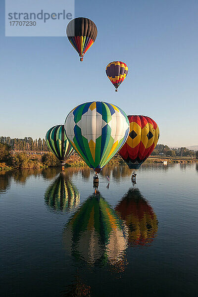 Heißluftballons der Prosser Balloon Rally schweben über und auf dem Wasser des Yakima River; Yakima River  Prosser  Washington