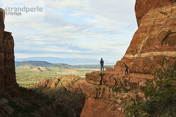 Eine junge Touristin fotografiert ihren Wanderpartner mit dem Handy  während er auf die Sedona-Schlucht blickt; Sedona  Arizona  Vereinigte Staaten von Amerika