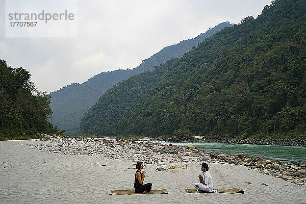 Yogastunde am Ufer des Ganges  der durch die Ausläufer des Himalaya zwischen Rishikesh und Devprayag im Tal des Ganges fließt  Uttarakhand  Indien; Rishikesh  Uttarakhand  Indien