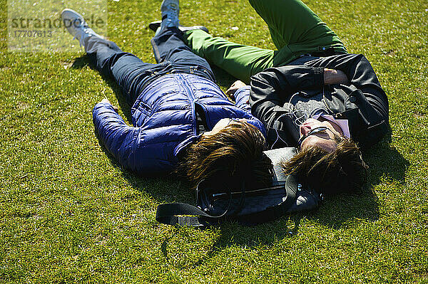 Ein Paar  das zusammen auf dem Gras in einem Park liegt  Bezirk Marais; Paris  Frankreich