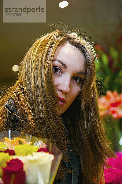 Eine junge Frau mit langen brünetten Haaren beim Einkaufen von Blumen; Paris  Frankreich