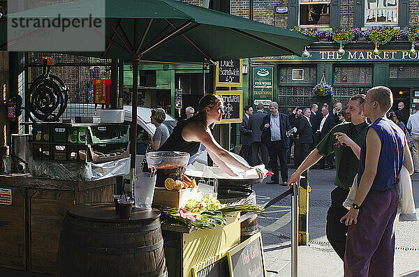 Stall in Borough Market mit Menschen stehen außerhalb Pub im Hintergrund; London  England