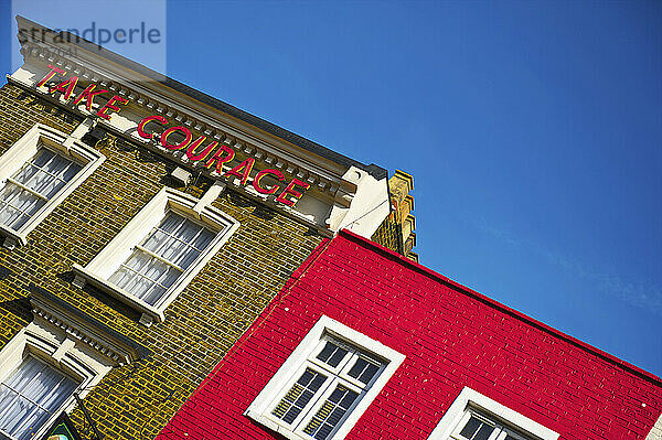 Ein Backsteingebäude mit einem Schild mit der Aufschrift Take Courage   Camden; London  England