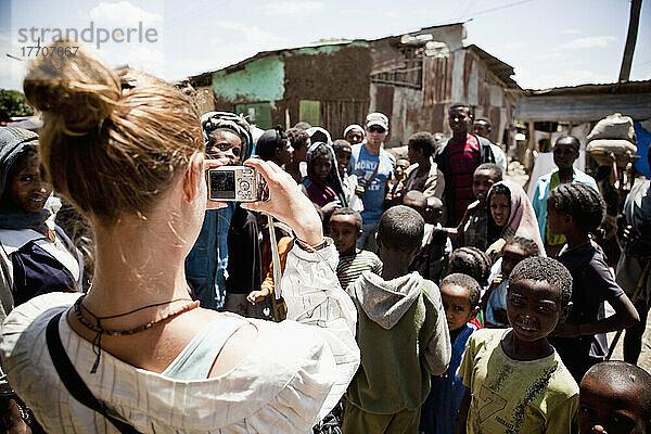 Junge Frau  die eine Gruppe interessierter Kinder fotografiert  Simien Mountains; Äthiopien