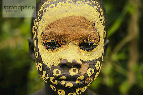 Surma-Kind  dessen Gesicht mit Pigmenten aus pulverisierten farbigen Steinen bemalt ist  Region Omo  Südwest-Äthiopien; Kibish  Äthiopien