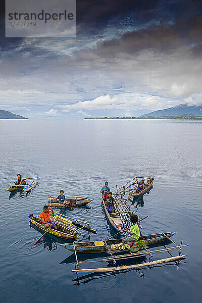 Junge Inselbewohner in Auslegerkanus verkaufen Muscheln vor der Insel Dobu auf den D'Entrecasteaux-Inseln in Papua-Neuguinea; Dobu  D'Entrecasteaux-Inseln  Papua-Neuguinea