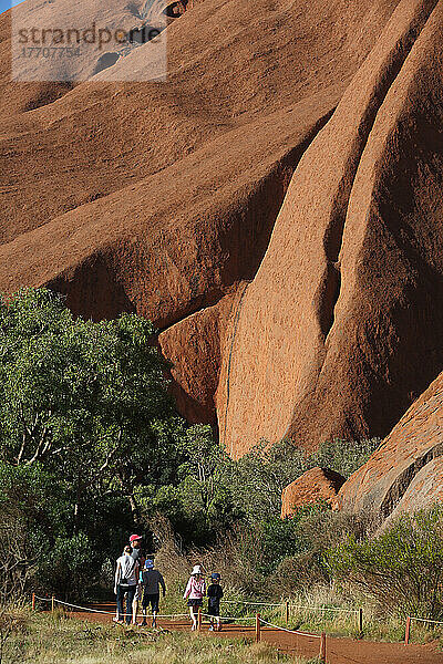 Touristen beim Spaziergang um den Uluru  früher bekannt als Ayers Rock; Northern Territory  Australien