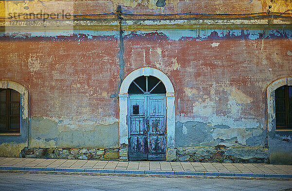 Ein altes Gebäude mit gewölbter Tür und Fenster; Sardinien  Italien