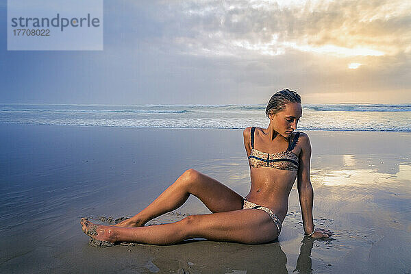 Junge Frau im Bikini am Tallows Beach bei Sonnenaufgang; New South Wales  Australien