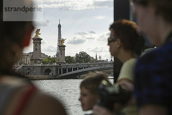 Touristen betrachten den Eiffelturm und die Pont de Alexandre III (Brücke Alexander III) von einer Bootsfahrt auf der Seine in Paris  Frankreich; Paris  Frankreich