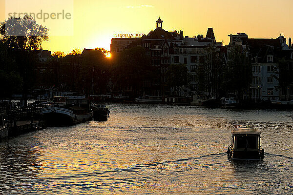 Kleines Boot auf dem Kanal in der Abenddämmerung; Amsterdam  Holland