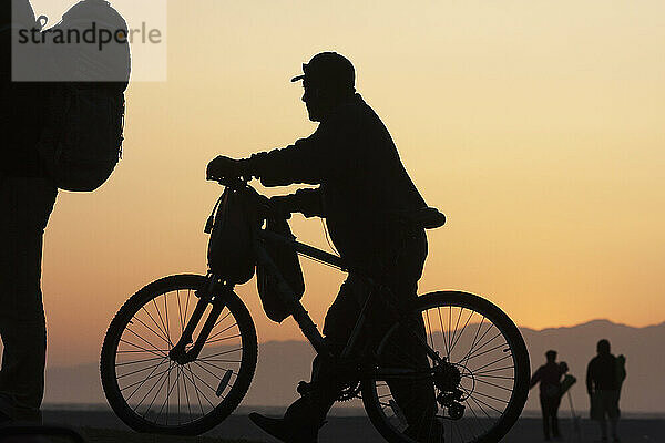 Silhouette von Radfahrern bei Sonnenaufgang; Kalifornien  Vereinigte Staaten von Amerika