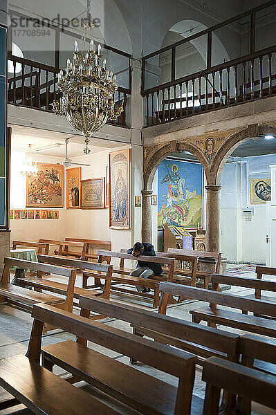 Ein Mann betet im Inneren der griechisch-orthodoxen Kirche St. Georg; Madaba  Jordanien