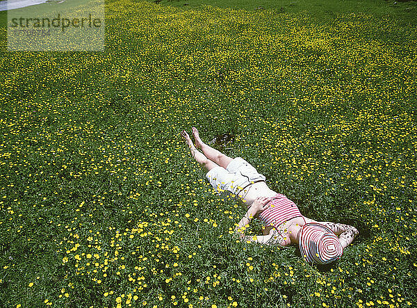 Frau entspannt im Feld der Butterblumen mit dem Cirque De Gavarnie im Hintergrund