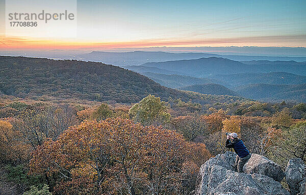Ein Mann fotografiert den Sonnenuntergang im Herbst am Bearfence Mountain im Shenandoah National Park  Virginia.