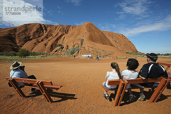 Touristen beobachten  wie Menschen den Uluru besteigen  früher bekannt als Ayers Rock; Northern Territory  Australien