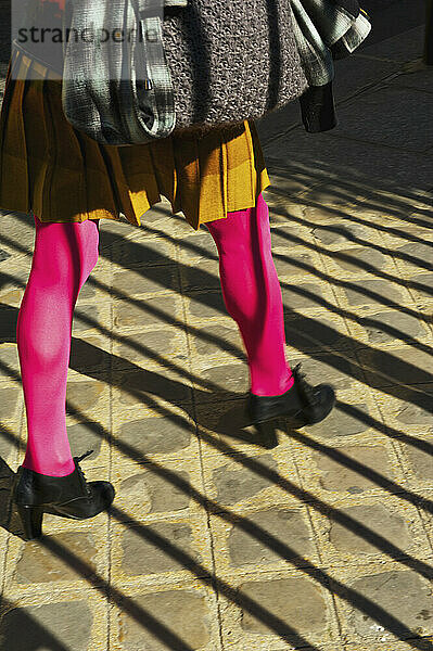 Eine Frau  die mit hellrosa Strumpfhosen und trendigen Schuhen spazieren geht  Marais-Viertel; Paris  Frankreich