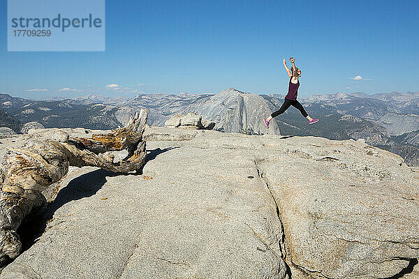 Ein Wanderer springt anmutig in einer Ballettbewegung auf den Sentinel Dome  einen felsigen Gipfel  der einen atemberaubenden Blick auf das Yosemite Valley bietet; Yosemite National Park  Kalifornien