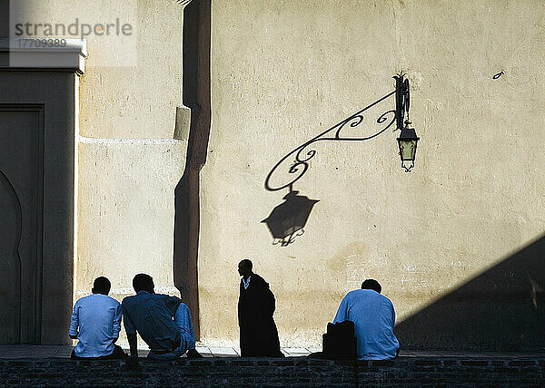 Männer entspannen sich im Schatten der Koutoubia-Moschee