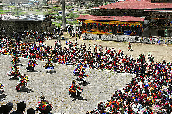 Kostümierte Tänzerinnen und Tänzer führen einen Cham-Tanz beim bhutanischen Paro Tshechu Festival im Paro Dzong  einem Kloster und einer Festung in Paro  Bhutan  auf; Paro  Bhutan