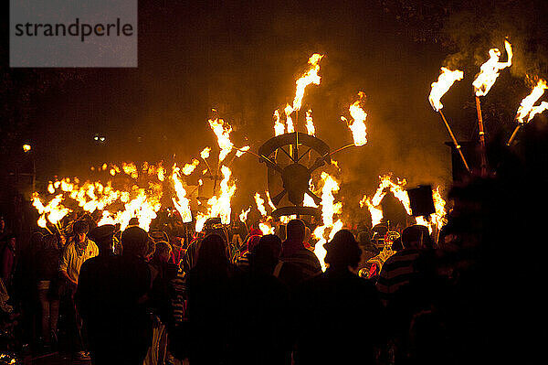 Menschen marschieren entlang der Straße für die East Hoathly Bonfire Night; East Sussex  England