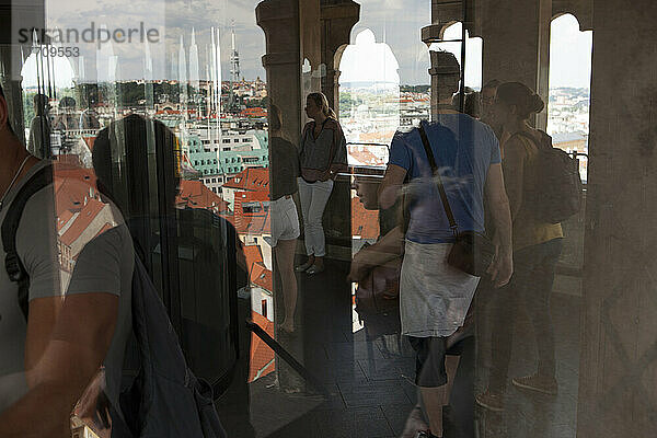Besucher und das Prager Stadtbild spiegeln sich in den Fenstern des Prager Altstädter Rathauses; Prag  Tschechische Republik