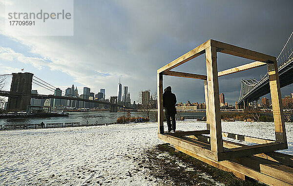 Mann  der auf einem Holzkubus steht  öffentliche Skulptur von Michael Clyde Johnson im Brooklyn Bridge Park  Brooklyn  New York City  New York  Vereinigte Staaten von Amerika