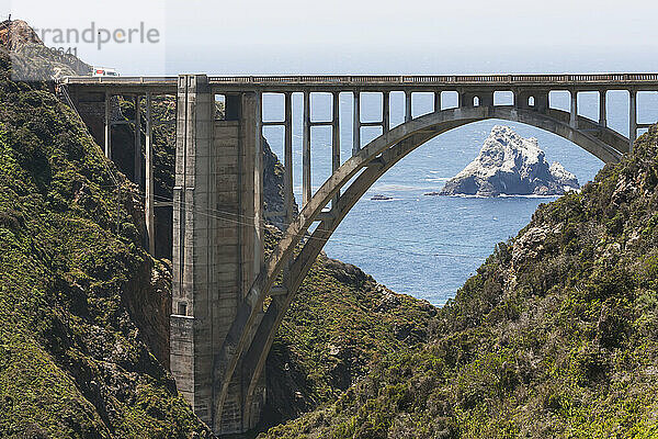 Straßenbrücke über die zerklüftete Küste mit einer Felsformation im Meer; Kalifornien  Vereinigte Staaten von Amerika