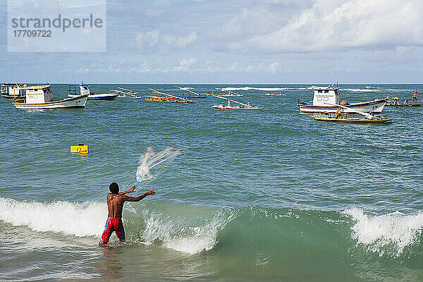 Ein Mann wirft ein Fischernetz vom Strand in Porto De Galinhas; Pernambuco  Brasilien