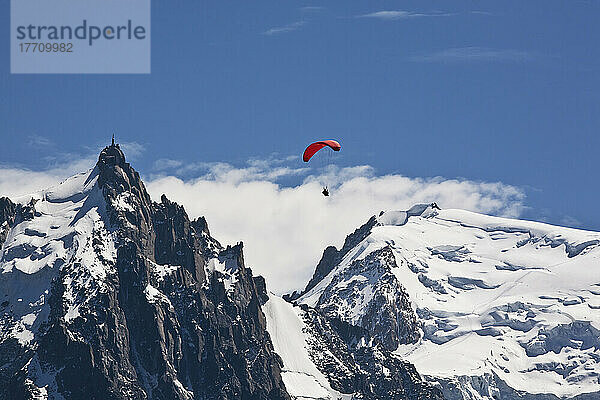 Gleitschirmflieger über dem Chamonix-Mont-Blanc-Tal  mit dem Mont-Blanc-Massiv und der Aiguille Du Midi im Hintergrund; Frankreich