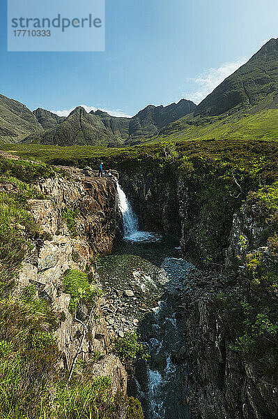 Mann betrachtet kleinen Wasserfall und einen der Fairy Pools in Coire Na Creiche  Black Cuillin; Isle Of Skye  Schottland