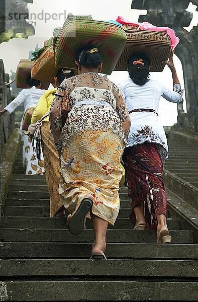 Parade in einer Zeremonie mit Frauen  die Opfergaben auf ihrem Kopf tragen; Bali
