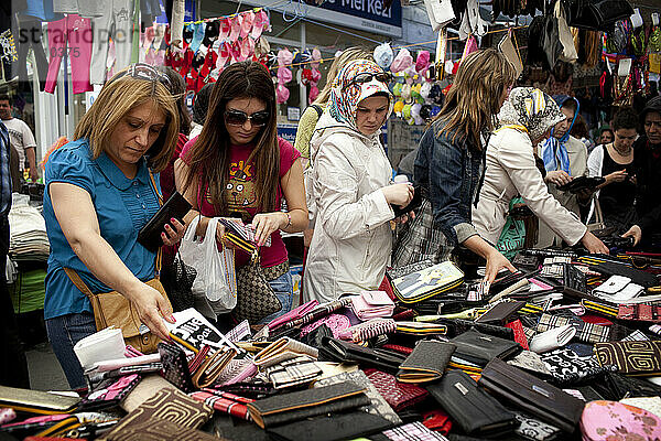 Frauen kaufen auf dem Carsamba Pazari  dem Mittwochsmarkt in Fatih  einem der ältesten und farbenprächtigsten Märkte Istanbuls  der sich in einem Straßennetz rund um die Fatih-Moschee in Istanbul  Türkei  befindet  abgezockte und gefälschte Handtaschen ein. Foto