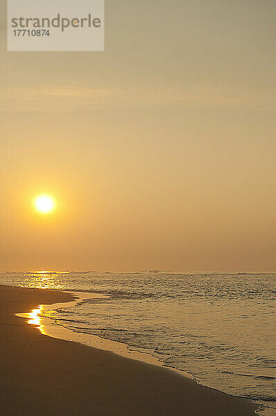 Blick entlang des Strandes zur aufgehenden Sonne  nahe Unawatuna; Thalpe  Sri Lanka