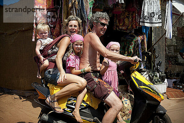 Die Familie Reynolds macht Urlaub in Goa und transportiert den Fünfer im indischen Stil auf einem Moped  Patnum Beach  Goa  Indien.