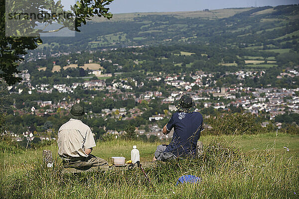 Wanderer bei einer Picknick-Mittagsrast auf dem berühmten 100-Meilen-Wanderweg Cotswold Way oberhalb von Cheltenham; Gloucestershire  England