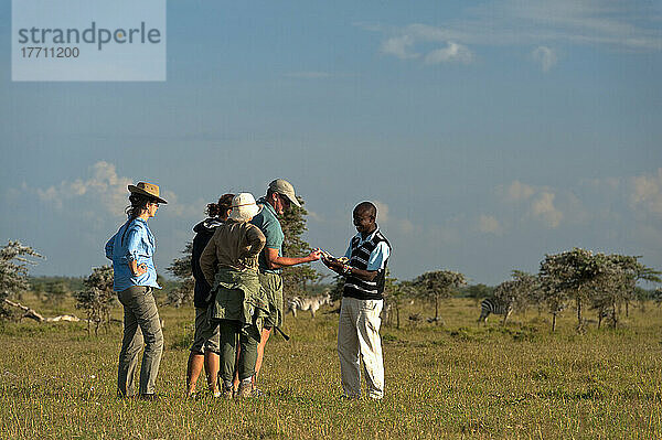 Führer zeigt Menschen Kieferknochen eines Tieres auf Wandersafari  Ol Pejeta Conservancy; Kenia