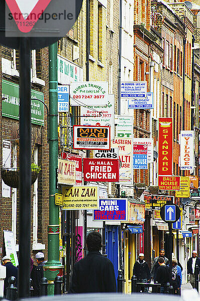 Eine Fülle von Schildern an den Seiten von Gebäuden in der Brick Lane; London  England