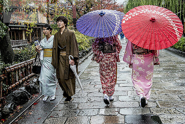 Japaner in traditioneller Kleidung spazieren nach einem Regenschauer entlang des Kamogawa-Flusses und im Gion-Viertel in Kyoto  Japan; Kyoto  Japan