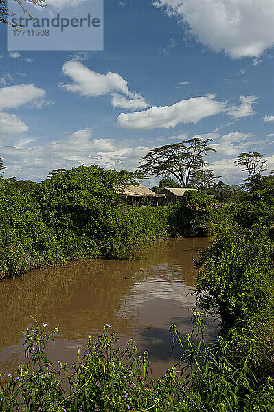 Blick über den Fluss zum Messezelt und Lounge-Zelt des Ol Pejeta Bush Camp  Ol Pejeta Conservancy; Kenia