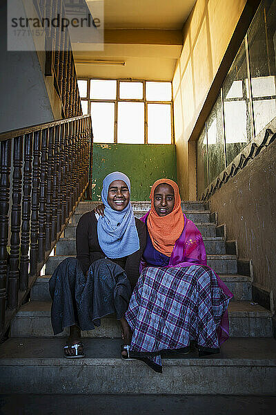 Junge verschleierte muslimische Mädchen  die auf den Stufen sitzen; Harar  Äthiopien