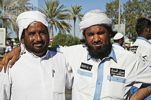 Porträt von zwei Männern vom Fischmarkt in einer Umarmung; Dubai  Vereinigte Arabische Emirate
